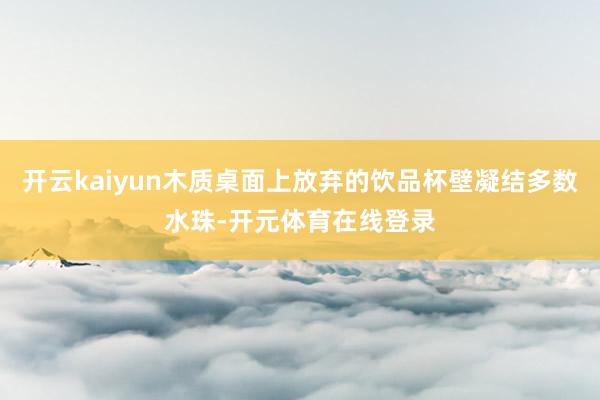 开云kaiyun木质桌面上放弃的饮品杯壁凝结多数水珠-开元体